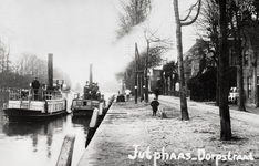 814911 Gezicht op de Dorpsstraat te Jutphaas, met links in het Merwedekanaal twee boten van Stoomtram- en Bargedienst ...
